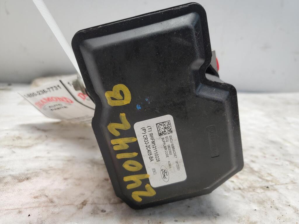 Used OEM ABS control module with mounting bracket and factory part number label